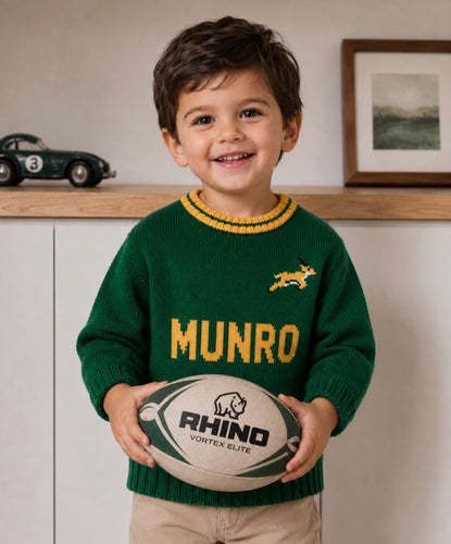 Child wearing personalised green and gold hand-knitted rugby jersey with animal design