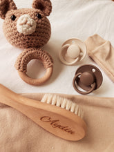 Close-up of personalised wooden baby hairbrush with engraved name